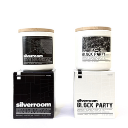 Two candles with labels 'Silverroom' and 'Block Party' on a white background